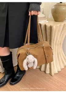 Dettaglio borsa tote marrone retrò con tracolla regolabile e ciondolo a forma di coniglio
