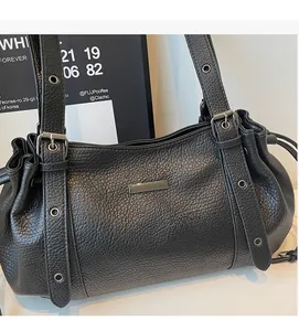 Close-up of black lychee textured leather tote with gunmetal hardware and strap details