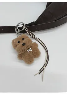 Detail of plush dog keychain with TOP DOG tag on a brown pebble leather strap