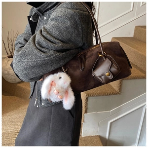 Details der dunkelbraunen Wildleder-Schultertasche mit Minibeutel und Plüschhasen-Anhänger