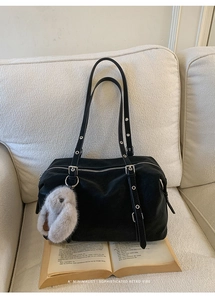 Borsa tote minimalista in pelle nera con tracolla ad occhielli e ciondolo a coniglio