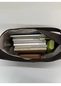 Spacious interior of a brown suede crescent bag showing tablet and daily essentials