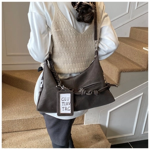 Side view of dark coffee crescent bag with woven strap and knot detail on a model