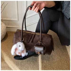 Detail der dunkelbraunen Wildleder-Hobo-Tasche mit Plüschhasen-Anhängern