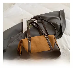 Close-up detail of the retro brown suede tote bag featuring leather stitching and metal rivets