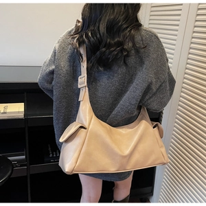 Détail du grand sac cabas beige avec large bandoulière réglable et poches latérales pratiques