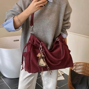 Chic burgundy canvas tote bag with drawstring closure and decorative mirror charm