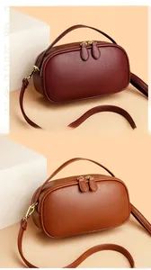 Detail view of burgundy and brown leather crossbody phone bags with gold zippers