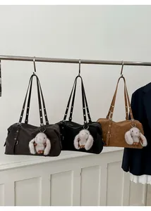 Tre borse tote in pelle marrone scuro, nero e kaki con graziosi ciondoli a forma di coniglio