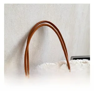 Detail of brown suede tote bag with white faux fur trim and reinforced leather handles