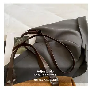 Close-up of adjustable brown leather shoulder strap with silver metal hardware on bag