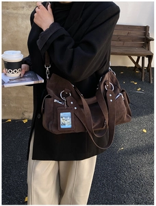 Detailed texture of dark coffee suede tote bag with metal rings and pockets