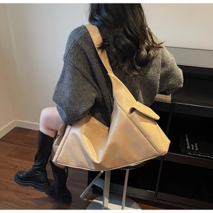 Vue arrière du mannequin portant un grand sac cabas minimaliste en similicuir beige