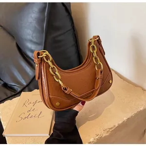 Close-up of brown crescent bag with pleated PU leather and chunky gold chain
