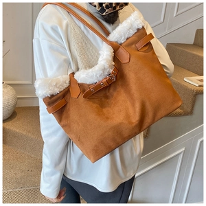 Détail d'un sac cabas en daim marron avec garniture en fausse fourrure blanche et boucle