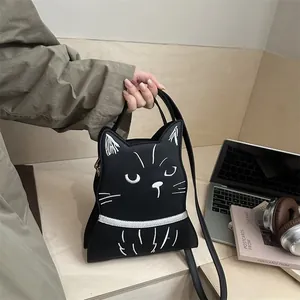 Détail du sac à bandoulière noir en forme de chat avec broderies et sangle fine