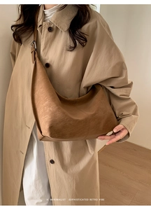 Close-up of minimalist retro brown leather hobo bag showing soft texture and drape