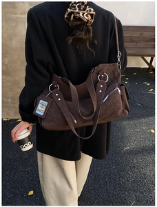 Detail of dark brown suede tote bag with side zipper and card holder on a model