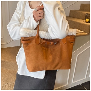Détail du sac cabas en daim marron avec bordure en peluche blanche et boucle décorative