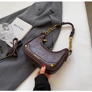 Detail of dark brown crescent bag with retro wrinkled leather and thick chain strap
