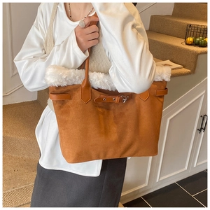 Detail of brown suede tote bag featuring white faux fur trim and silver buckle accents