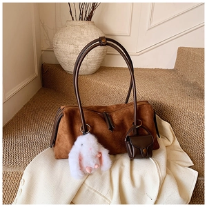 Detail der braunen Wildleder-Schultertasche mit Plüschhasen-Anhänger und Mini-Beutel