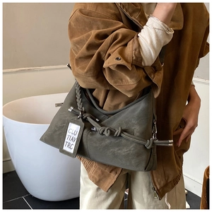 Detail of olive green slouchy hobo bag featuring thick braided rope strap and knotted detail