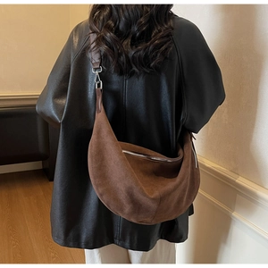 Dettaglio della borsa hobo in pelle scamosciata marrone con zip argento e tracolla larga