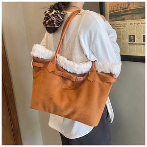 Détail du sac cabas en daim marron avec bordure en peluche blanche et sangle en cuir