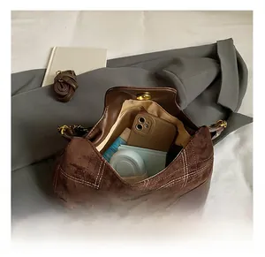Detailed interior of brown suede crescent bag with quilted stitching and large capacity
