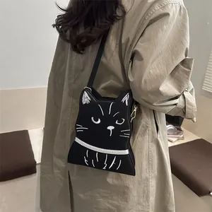 Détail du sac bandoulière chat noir avec broderie blanche sur une surface en cuir mat doux
