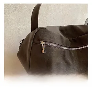 Close-up of premium textured brown tote bag featuring a polished silver zipper detail