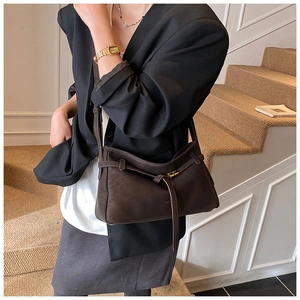 Detail of soft dark brown leather tote with a stylish gold rectangular buckle and strap