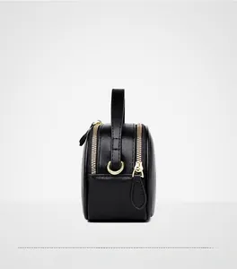 Detail view of premium black leather bag with double gold zippers and side profile
