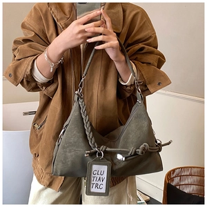 Detail of army green hobo bag with braided handle and decorative knotted rope detail