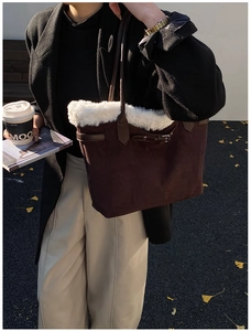 Détail d'un sac cabas en daim marron avec garniture en fausse fourrure blanche et cuir