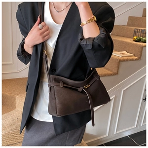 Detail of dark coffee faux leather tote with golden buckle and sleek shoulder strap