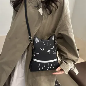 Détail du sac à bandoulière noir en forme de chat avec coutures contrastées et accents dorés