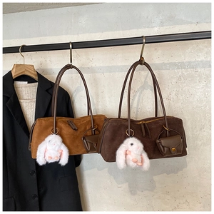 Detailansicht von Wildleder-Hobo-Taschen mit Kaninchenanhängern und Mini-Taschen