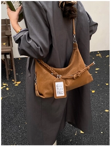 Close-up of retro brown hobo bag with woven strap and mini card holder detail