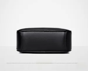 Close-up detail of genuine leather bottom with lychee texture on black handbag