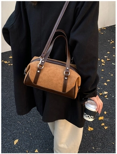 Retro brown suede pillow bag with dual handles shown on a street with autumn leaves
