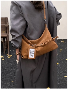 Caramel retro hobo bag with braided knot strap details shown on a model's shoulder