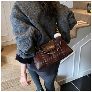 Detail of vintage dumpling bag with brown plaid leather and golden chain accessory