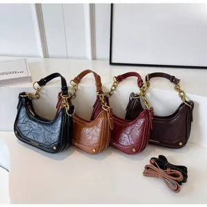 Detail view of crescent shoulder bags in four vintage colors with metal chain straps
