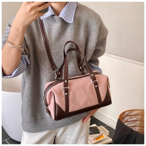 Detail of pink and brown contrast stitching Boston bag with silver metal zippers and strap