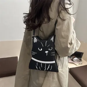 Détail du joli sac bandoulière en forme de chat noir porté par un mannequin
