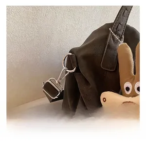 Detail of dark brown leather tote with silver metal hardware and cute rabbit plush charm