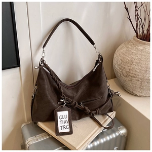 Detail of dark brown vintage shoulder bag with textured leather and woven rope accents