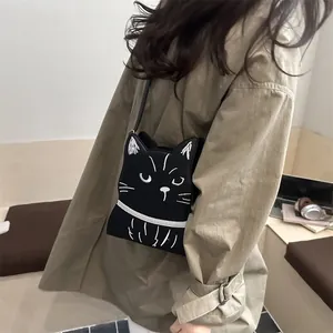 Détail du sac bandoulière chat noir avec broderie faciale mignonne et bandoulière fine